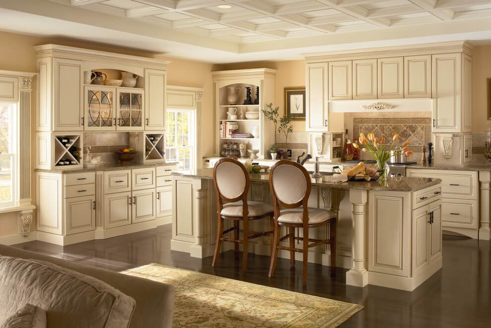 کابینت لوکس سفید آشپزخانه دارای حاشیه منبت کاری شده در اطراف درب‌ها و صفحه سنگی
