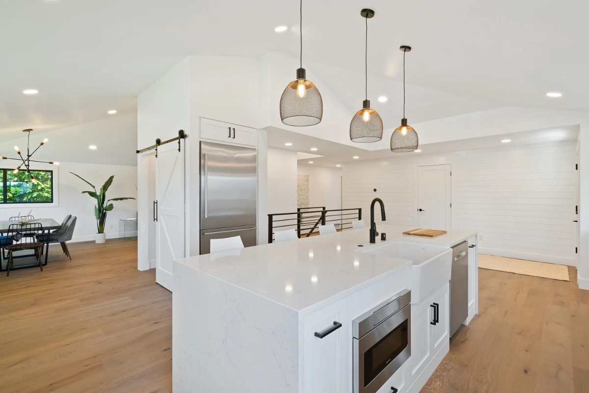 بزرگ نشان دادن آشپزخانه با نور لوسترهای مدرن و کابینت سفید