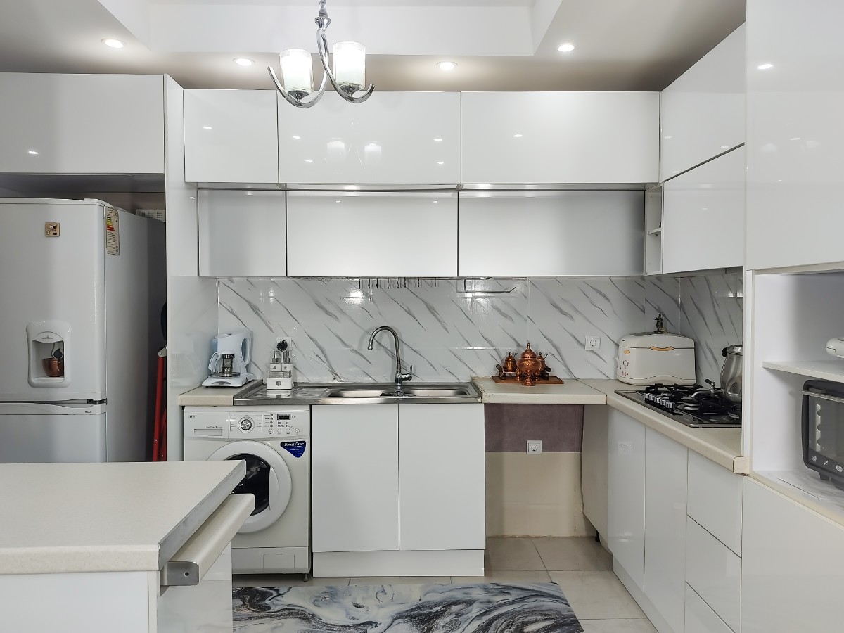 بزرگ نشان دادن آشپزخانه با کابینت سفید مدرن دو پله
