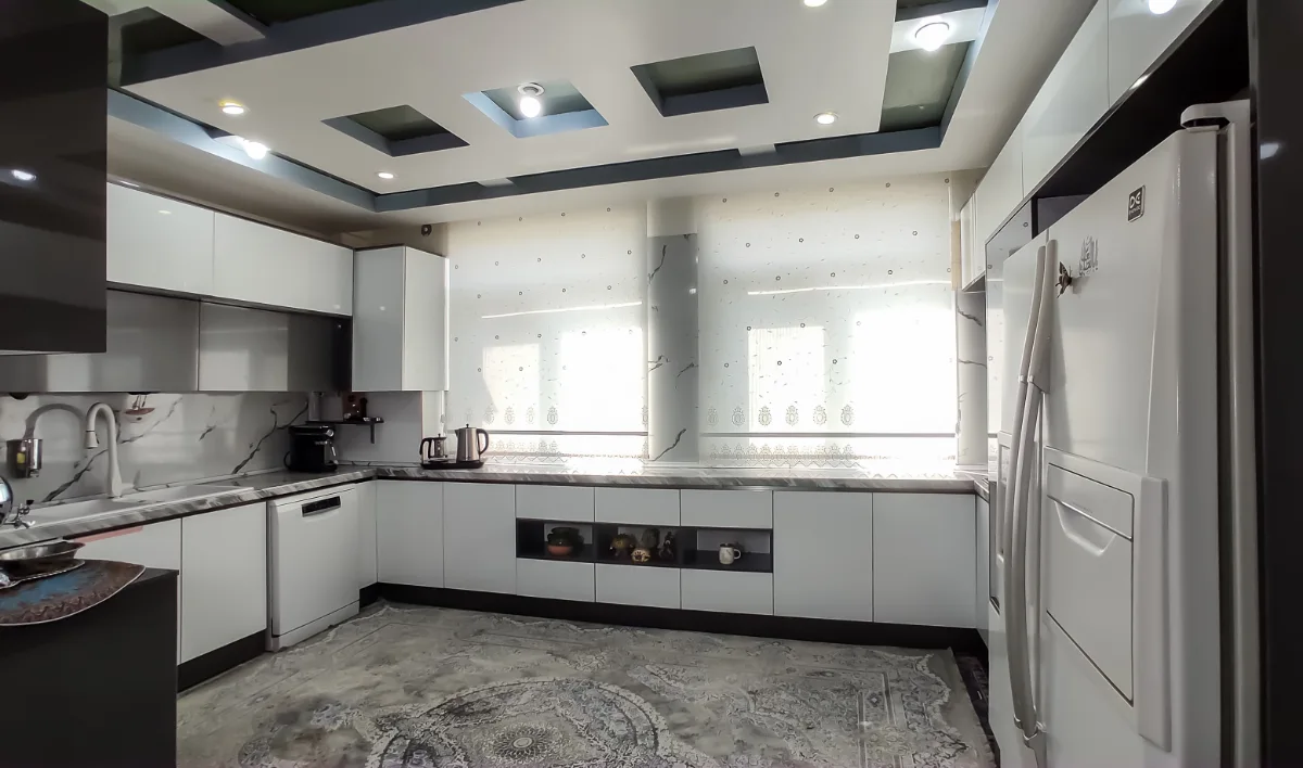 آشپزخانه سفید طوسی بزرگ با پنجره و فرش طوسی
