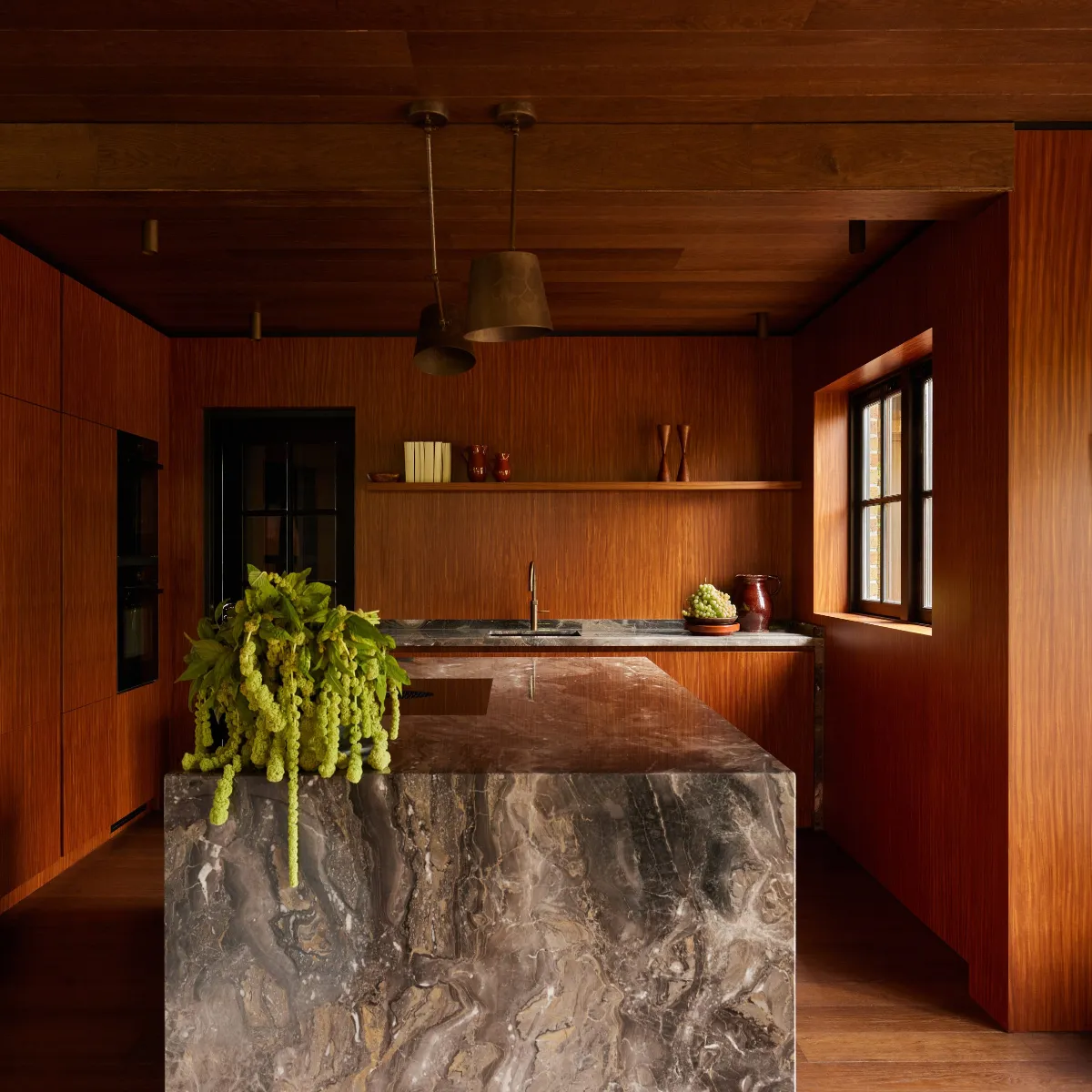 آشپزخانه مدرن الهام گرفته از طبیعت با دیوارهای چوبی و جزیره سنگی