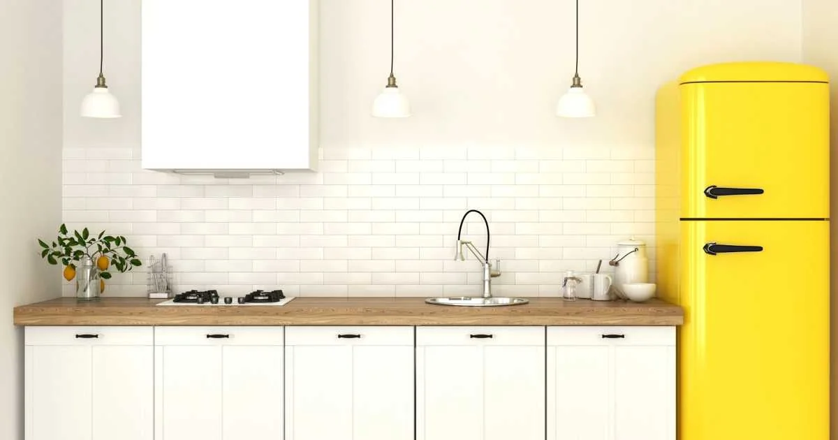 آشپزخانه با کابینت‌های سفید و بین‌کابینتی آجری سفید و یخچال زرد