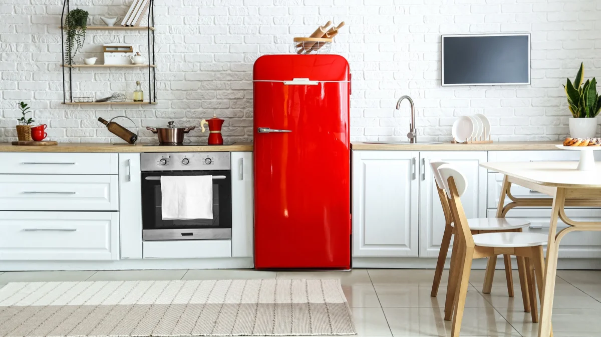 آشپزخانه با کابینت سفید و صفحه کابینت چوبی و یخچال قرمز براق