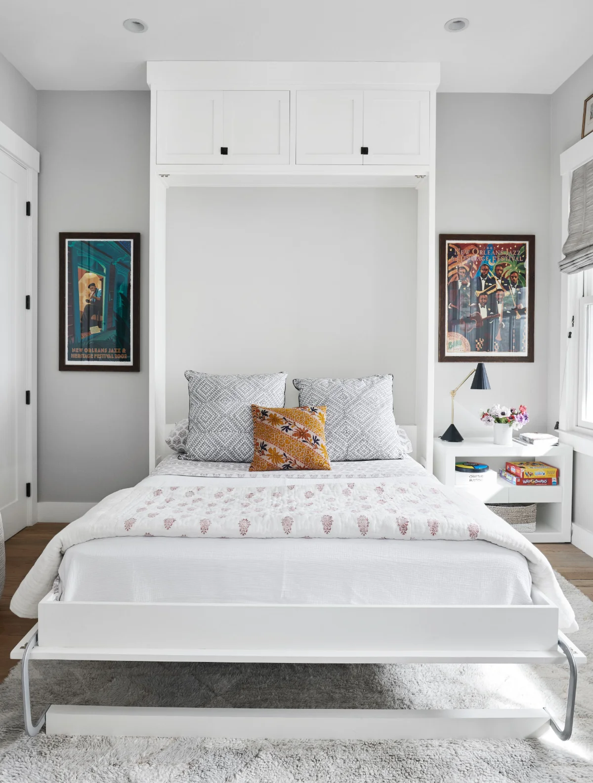 اتاق‌خواب با تخت خواب تاشوی سفید، داخل کمدی دیواری سفید با دستگیره‌های مشکی